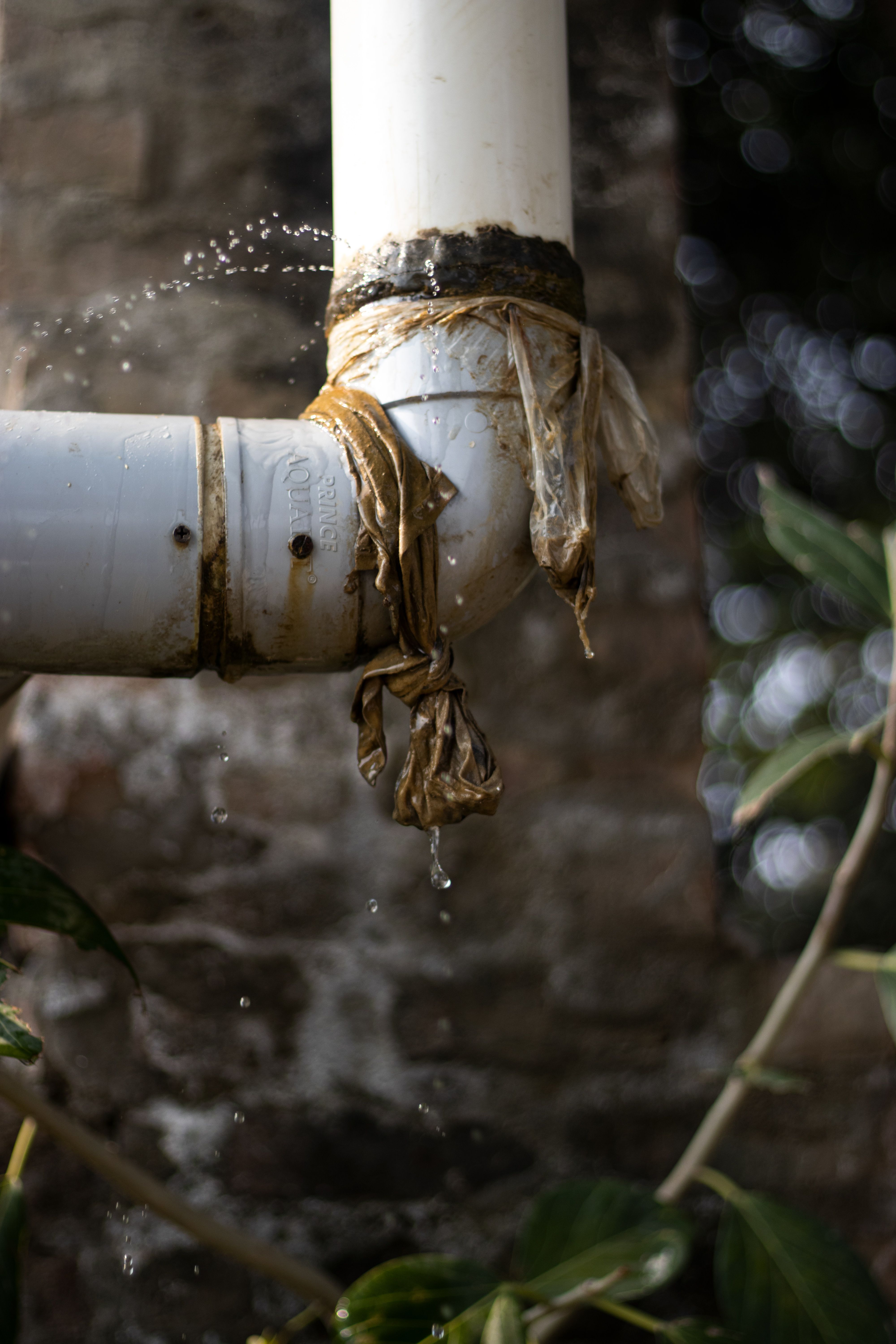Plumber inspecting a pipe for a hidden water leak